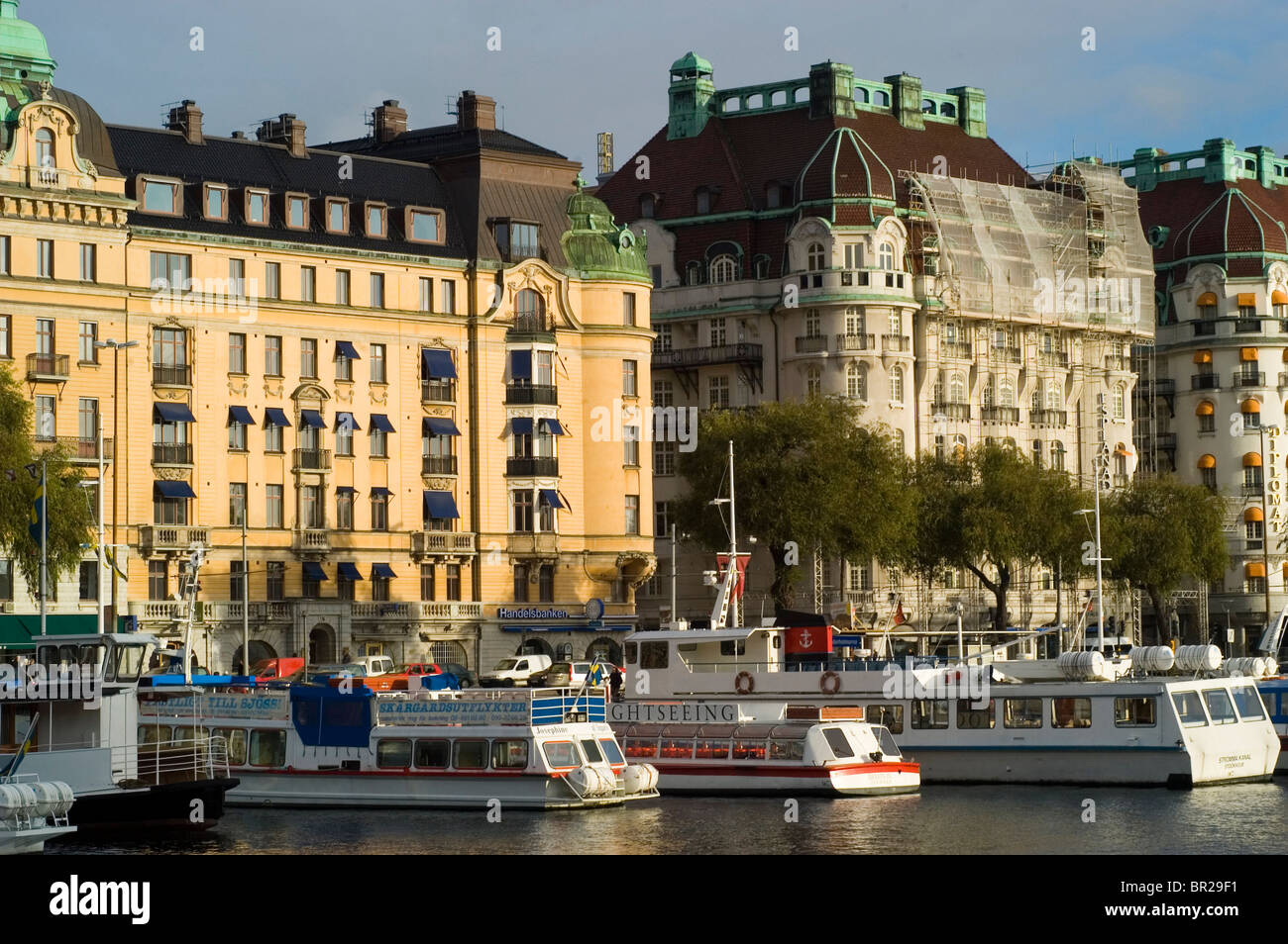 Ausflugsboote packen der Waterfront, vor alten Hotels und Wohnanlagen in Stokholm, Schwedens historische Innenstadt. Stockfoto