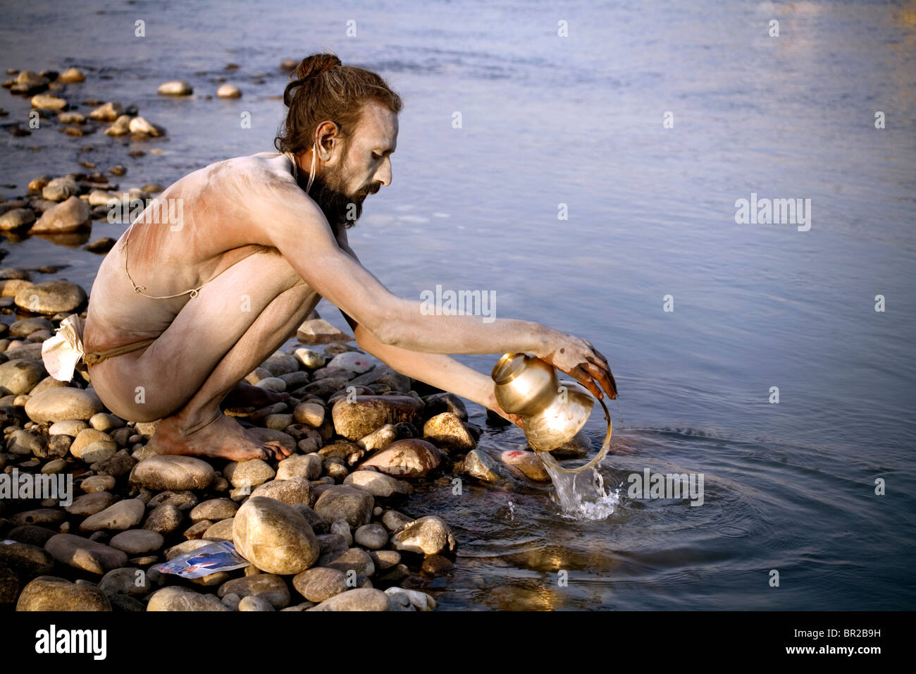 Ein Sadhu heiliger Mann wäscht seine Schale im Fluss Ganges, Haridwar, Uttarakhand, Indien. Stockfoto