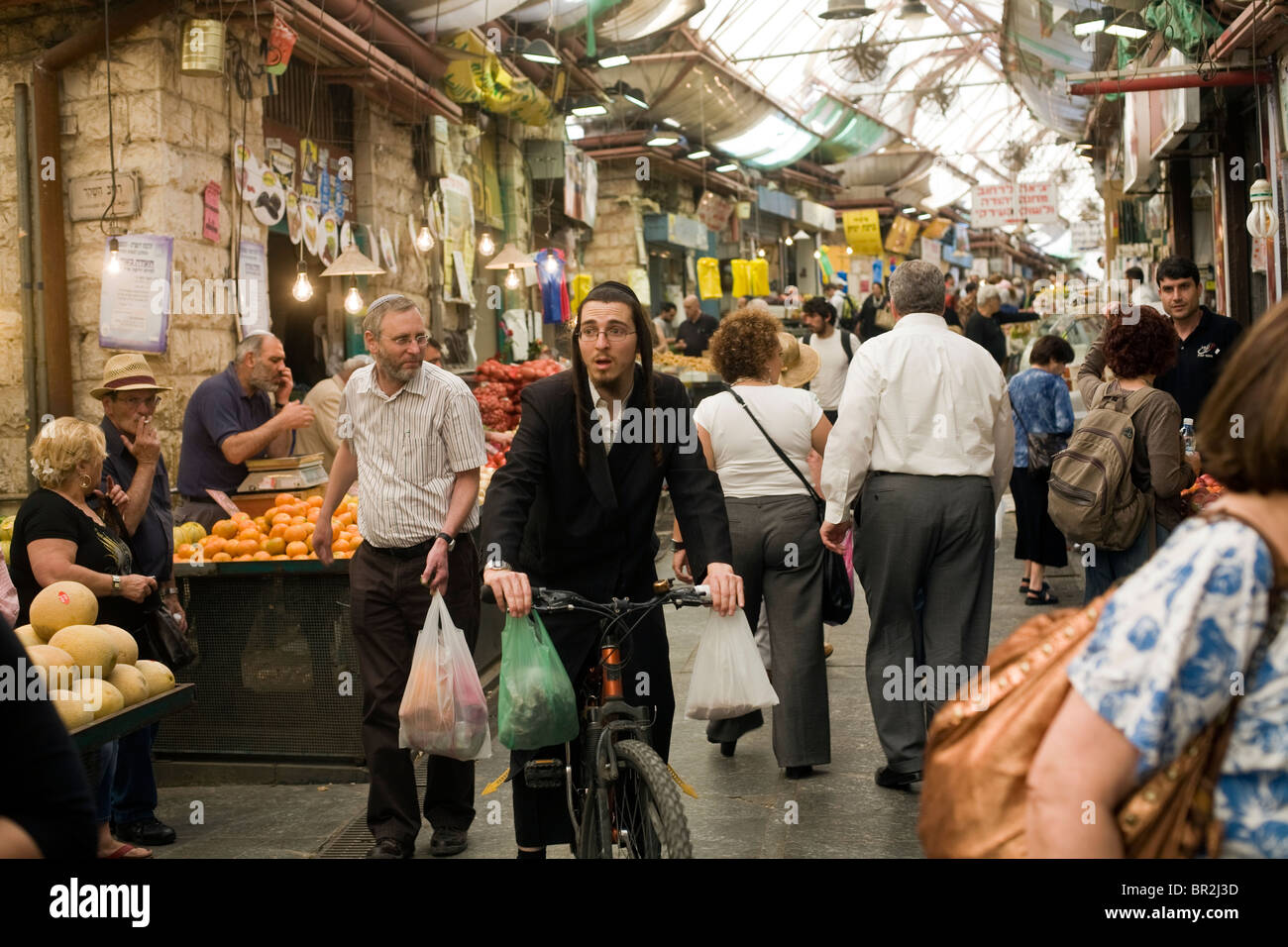 Ein orthodoxer Jude mit dem Fahrrad Einkaufen bei Mahane Yehuda Markt, Jerusalem, Israel Stockfoto