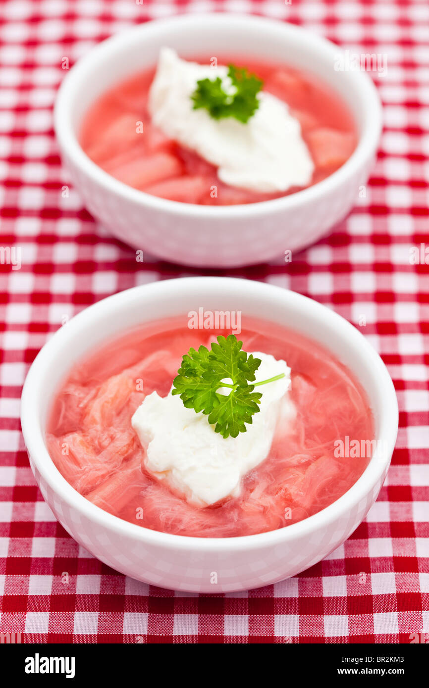 Zwei Gerichte geschmorte Rhabarber mit Joghurt auf einem roten und weißen Tuch Stockfoto