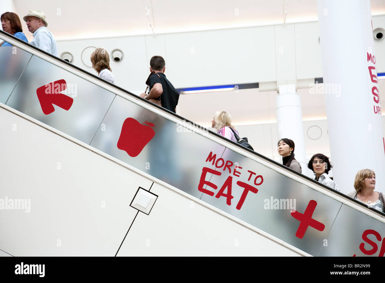 Menschen gehen die Rolltreppe hinauf zu den Restaurants, Abfahrten