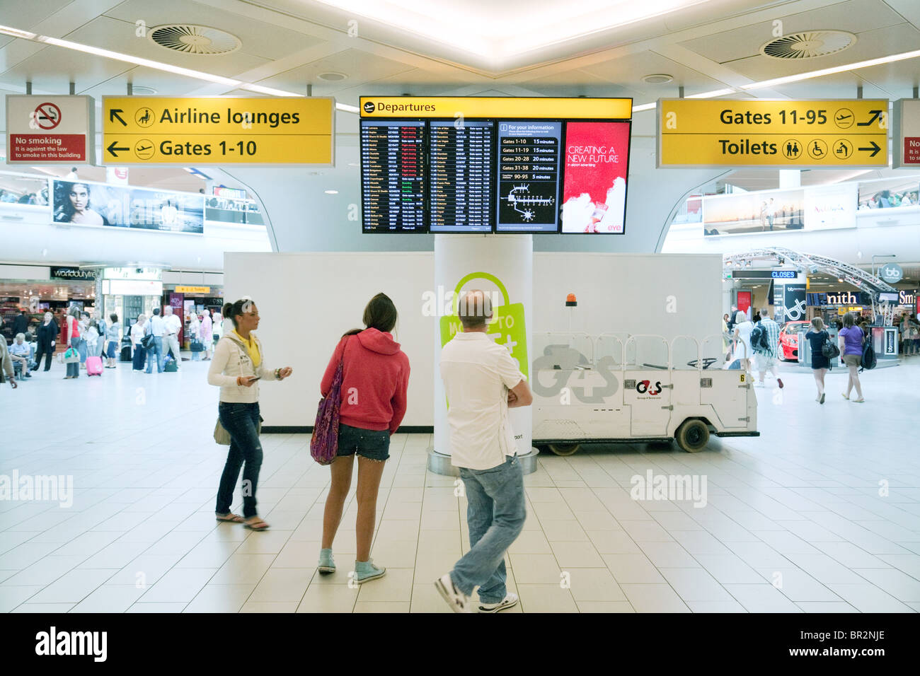 Passagiere, die Blick auf die Anzeigentafel, Abfahrten, Süd-Terminal, Flughafen Gatwick UK Stockfoto