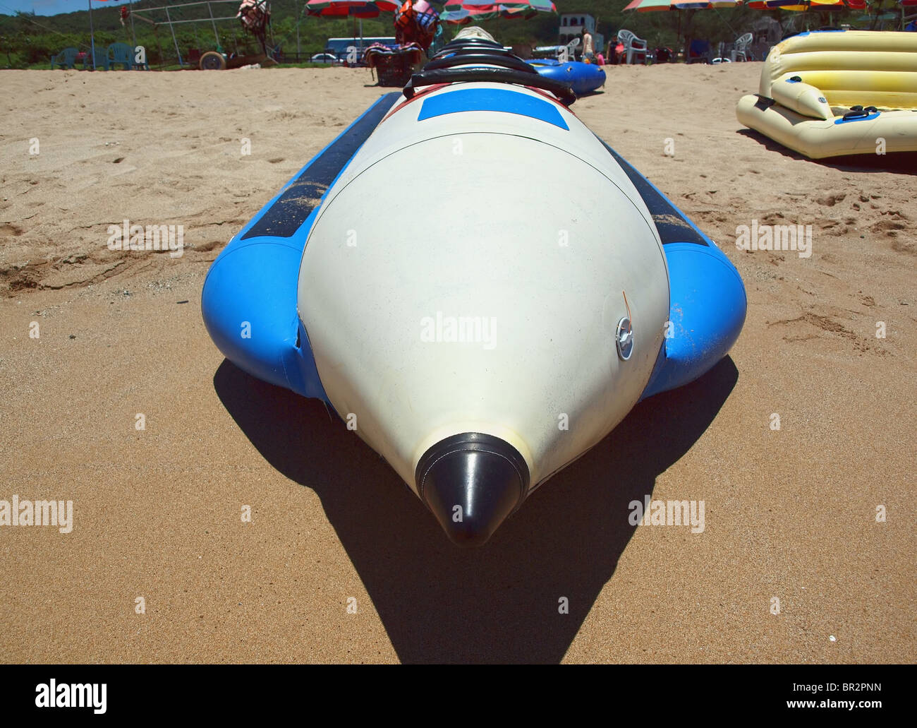 Aufblasbares Wasserfahrzeug sitzt an einem Sandstrand. Diese Art von Boot nennt man auch Banana-Boat. Stockfoto