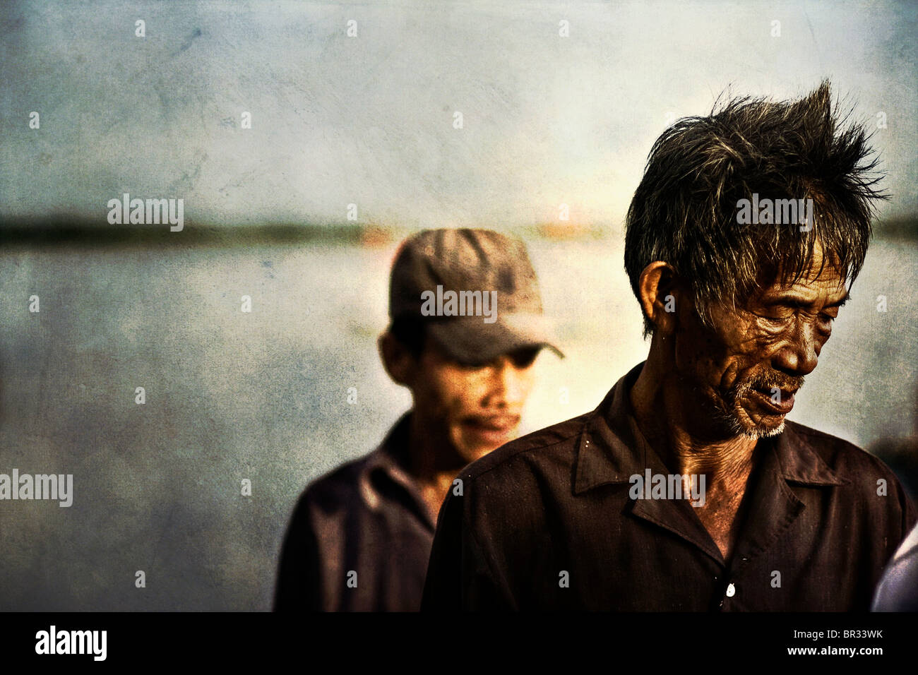 Zwei Männer, erschöpft von den Ausgaben ein Nachtangeln in einem Boot, in einem Fischerdorf in der Nähe von Hoi an, Vietnam Stockfoto