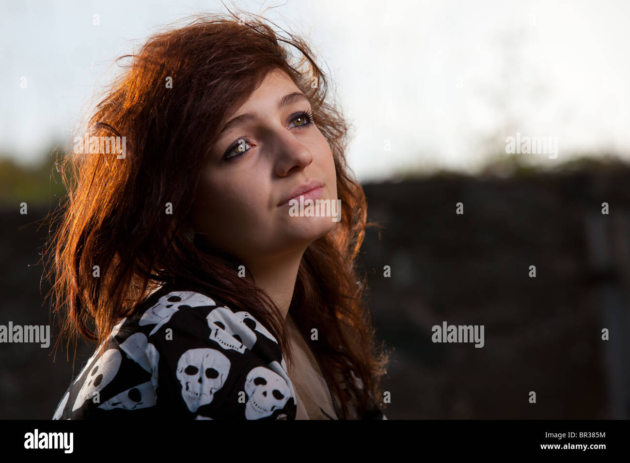 Kopfschuss / Porträt eine attraktive dunkelhaarige junge Frau mit dem Sonnenlicht auf ihr Haar Stockfoto