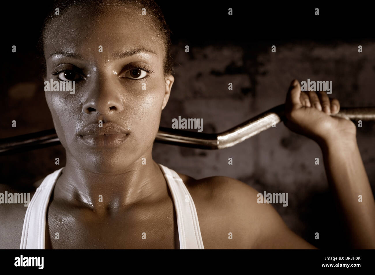 Young African American Woman, Krystle Thornton, hebt Gewichte beim Blick in die Kamera. Stockfoto