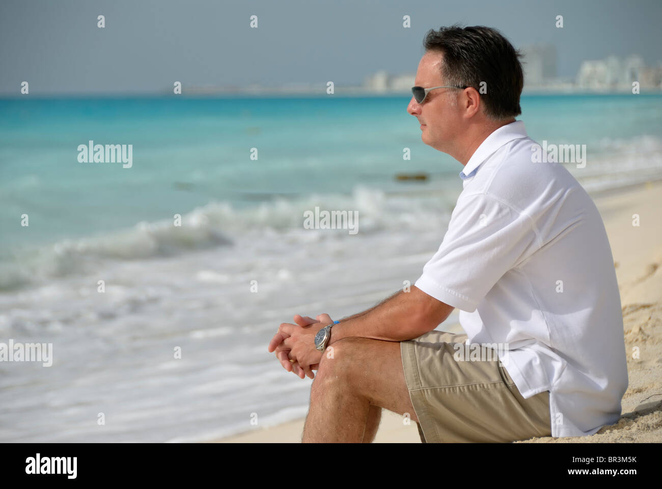 Cancun, Quintana Roo/Mexiko - 24. Juli 2007: erwachsener Mann auf dem Sand am Strand in Cancun sitzt Stockfoto