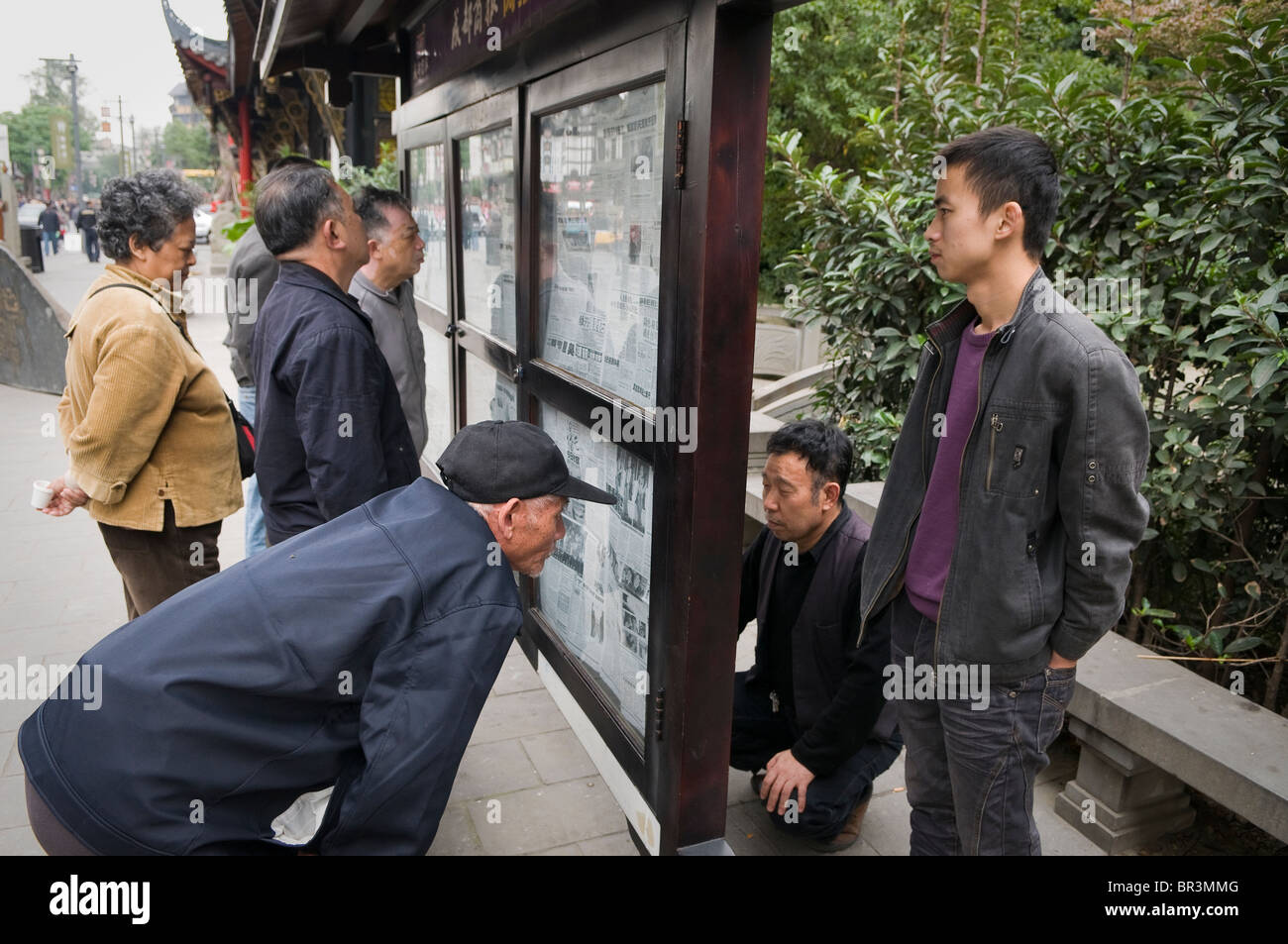 Besucher, Fußgängerzone-Pause um Zeitungen zu lesen in der Nähe von Wenshu Tempel, Chengdu, Provinz Sichuan, China Stockfoto