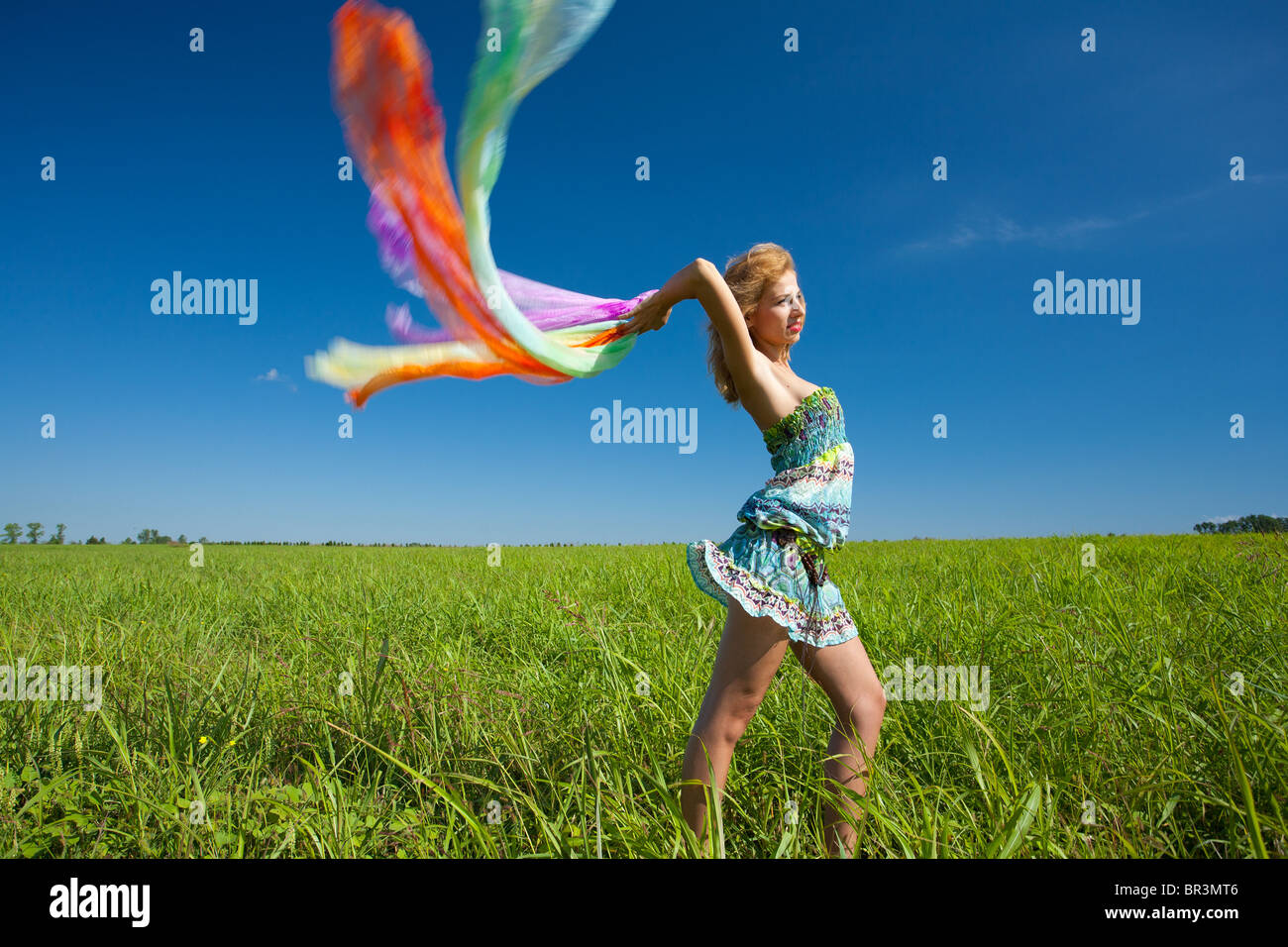 Schöne blonde Frau mit bunten Schal im Wind, Bewegungsunschärfe Stockfoto