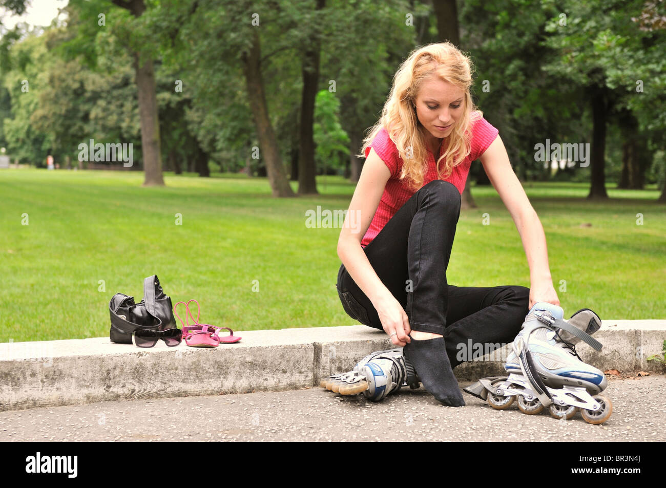 Junge Frau, die auf Rollschuhen - draußen im park Stockfoto