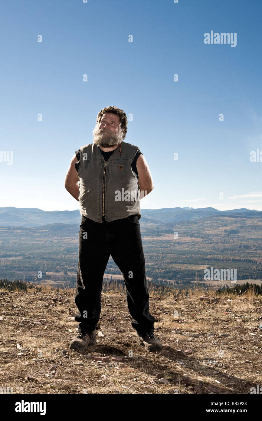 Oben auf einem Plateau steht ergrauten Mann stolz. Stockfoto