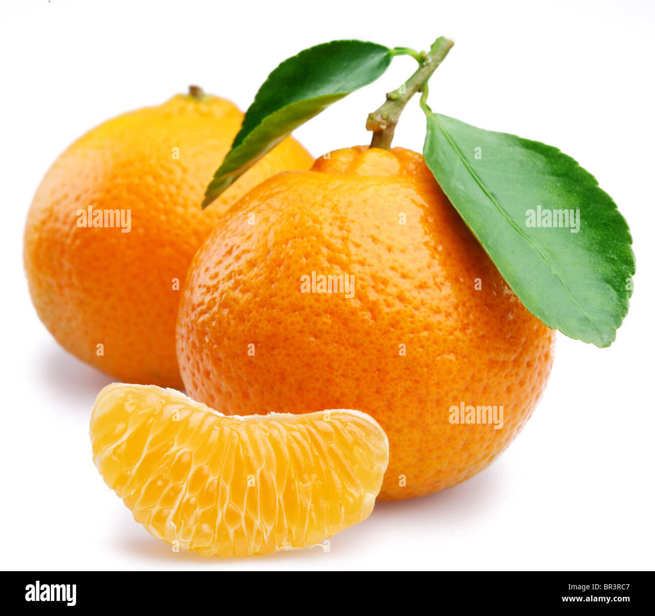 Reife Mandarinen mit Blättern und Scheiben auf weißem Hintergrund Stockfoto
