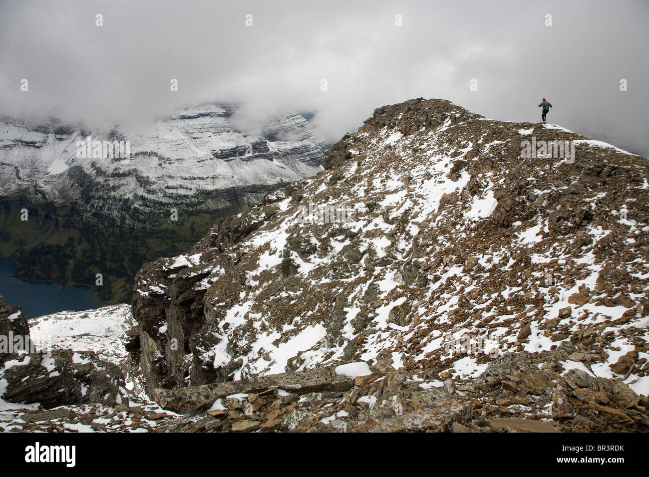 Eine junge Frau läuft entlang der schmalen Grat eines Peaks im Glacier Nationalpark, Mt. Stockfoto