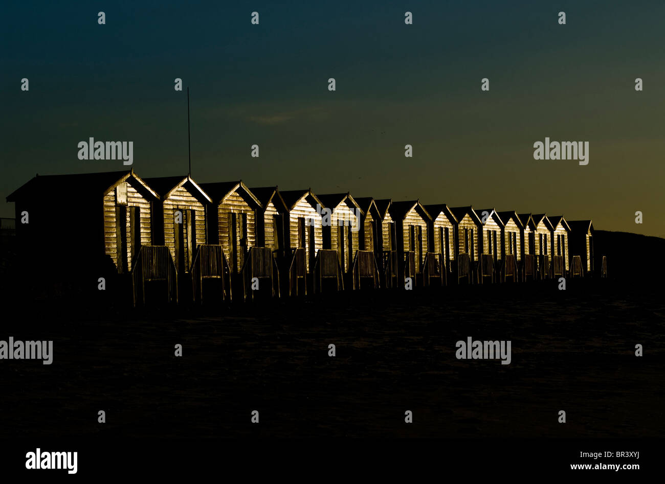 Eine Reihe von hölzernen Strandhütten bei Sonnenaufgang in Muizenberg, Kapstadt Stockfoto