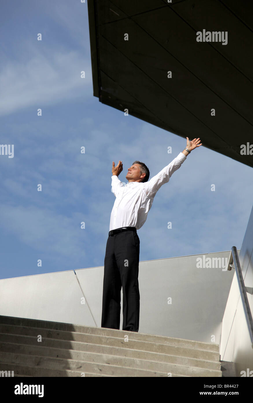 Geschäftsmann, seine Arme im freien Stockfoto