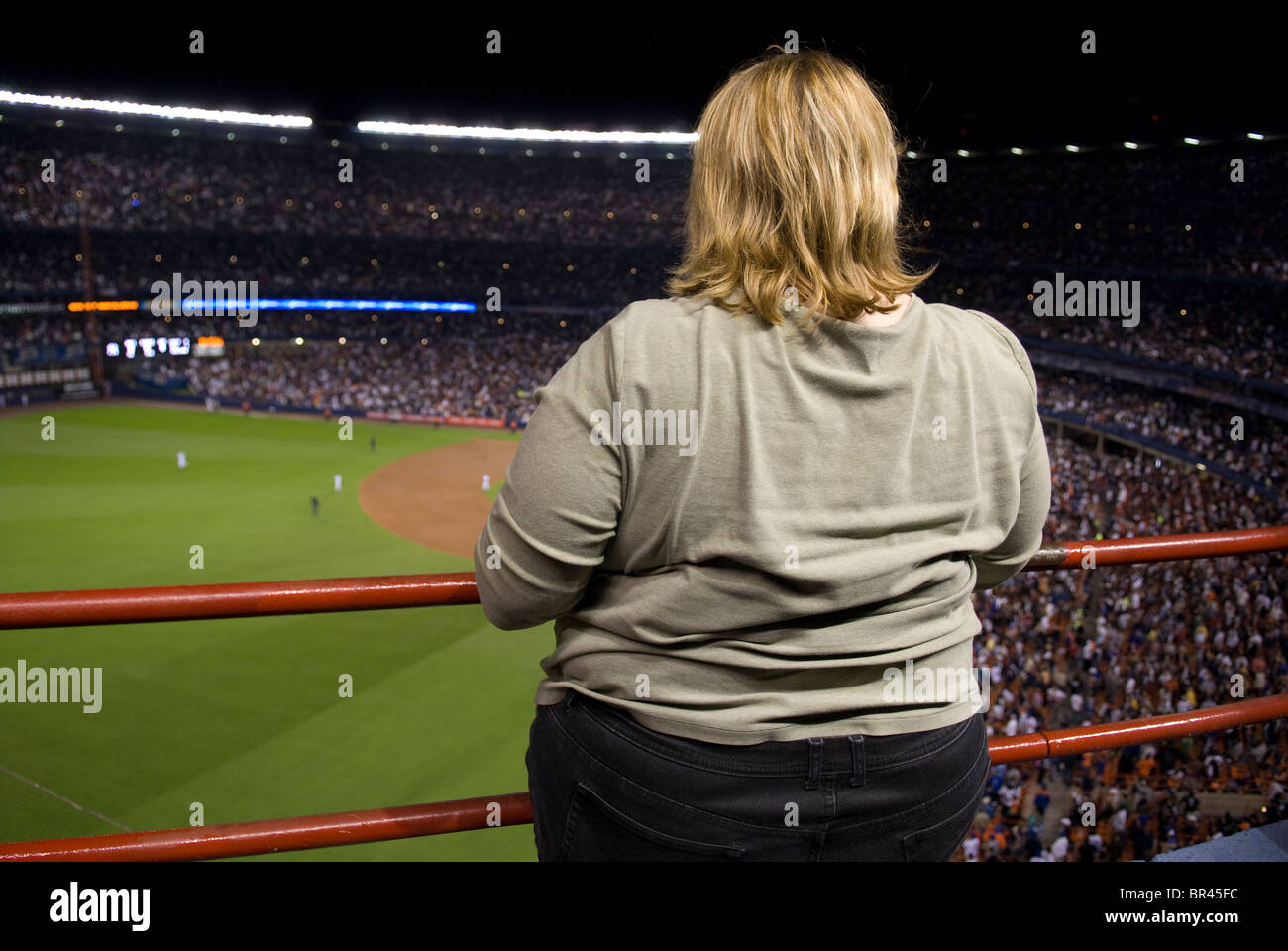 schwere Frau bei Rail im Oberdeck im professionellen Baseball-Spiel Stockfoto