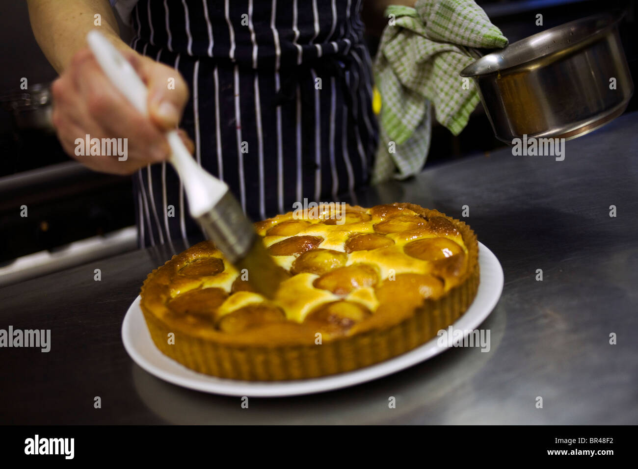 Ein Koch Verglasung eine Aprikosen-Tarte. Stockfoto