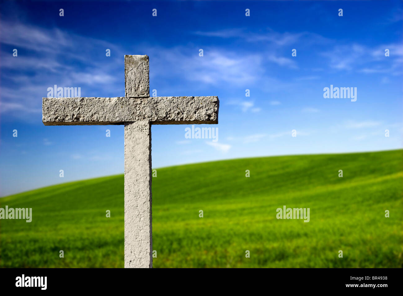 Religiöse Steinkreuz auf einem schönen grünen Hügel Stockfoto
