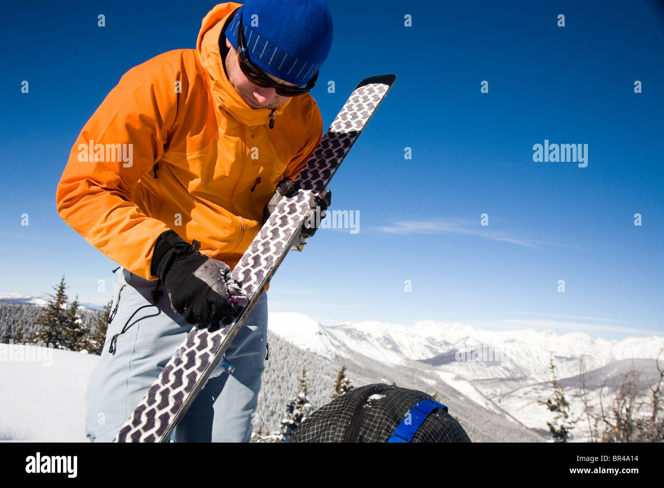 Ein Skifahrer nimmt sich eine Auszeit und Skitouren um die Felle auf seinen Skiern, Colorado zu setzen. Stockfoto