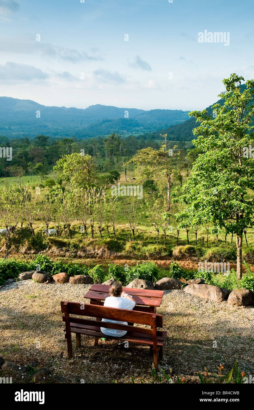 Eine junge Frau, die ein Buch draußen ein Öko-Hotel in der Nähe von La Fortuna, Arenal Region, Costa Rica, Mittelamerika Stockfoto