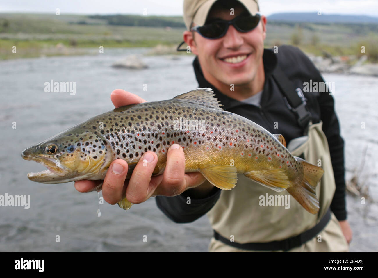 Mann lächelt halten Sie einen Fisch in Montana. Stockfoto
