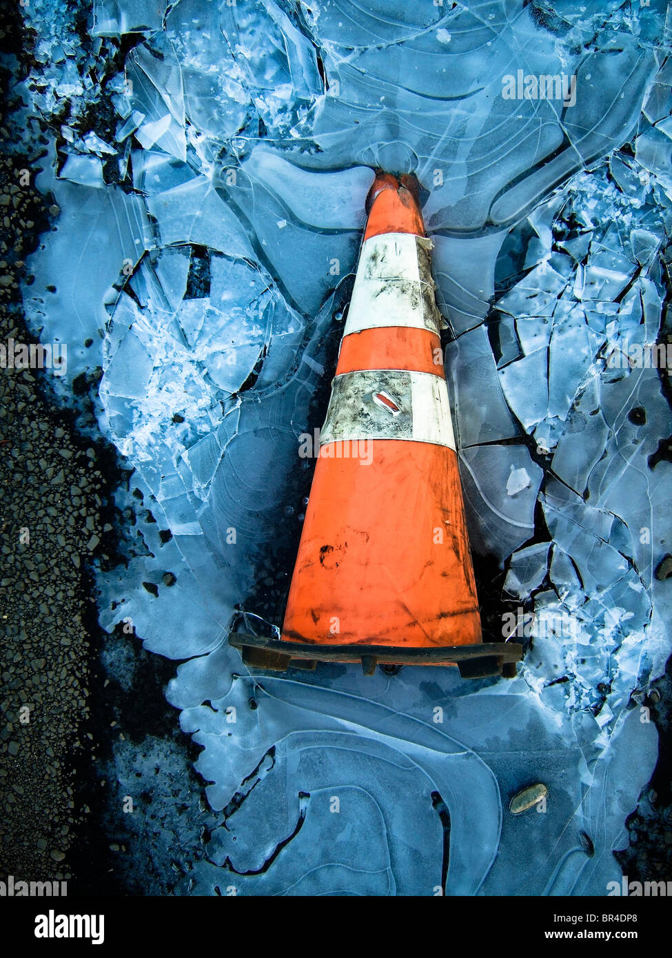 Ein Bau-Kegel liegt in den Überresten einer gefrorenen Pfütze in Seattle, Washington. (Nahaufnahme) Stockfoto