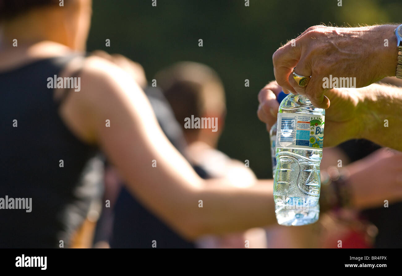 Kleine Kunststoff-Flaschen von Buxton immer noch Mineralwasser Konkurrenten in Nottingham Marathon übergeben wird Stockfoto