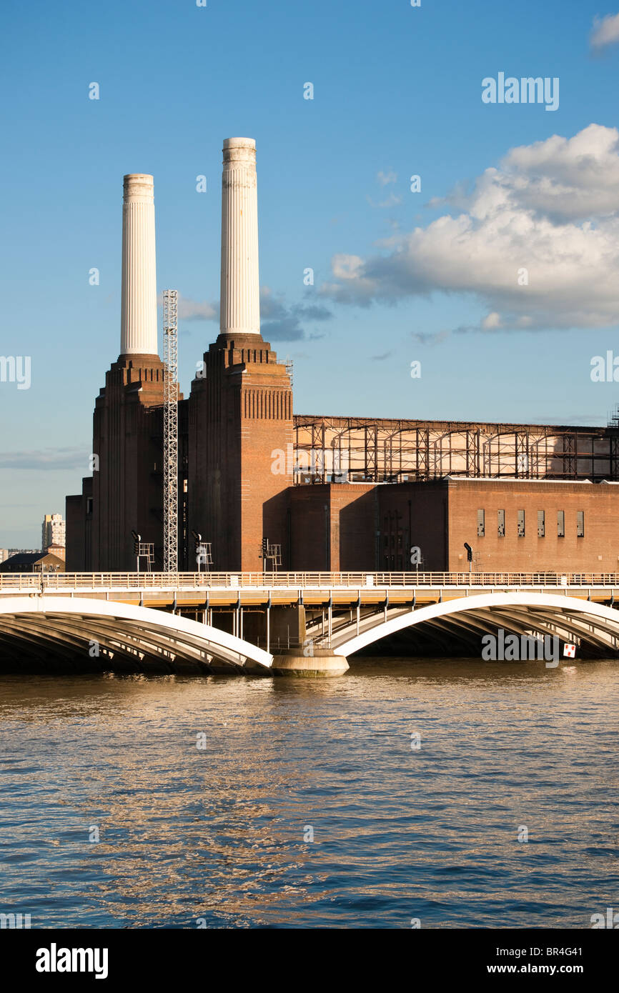 Battersea Power Station und Brücke über den Fluss Themse mit Reflexion, gegen blauen Himmel mit weißen Wolken Stockfoto