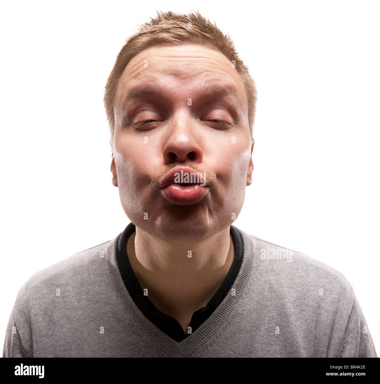 Lustiger Mann versucht, einen Kuss zu geben. Isoliert auf weiss. Stockfoto