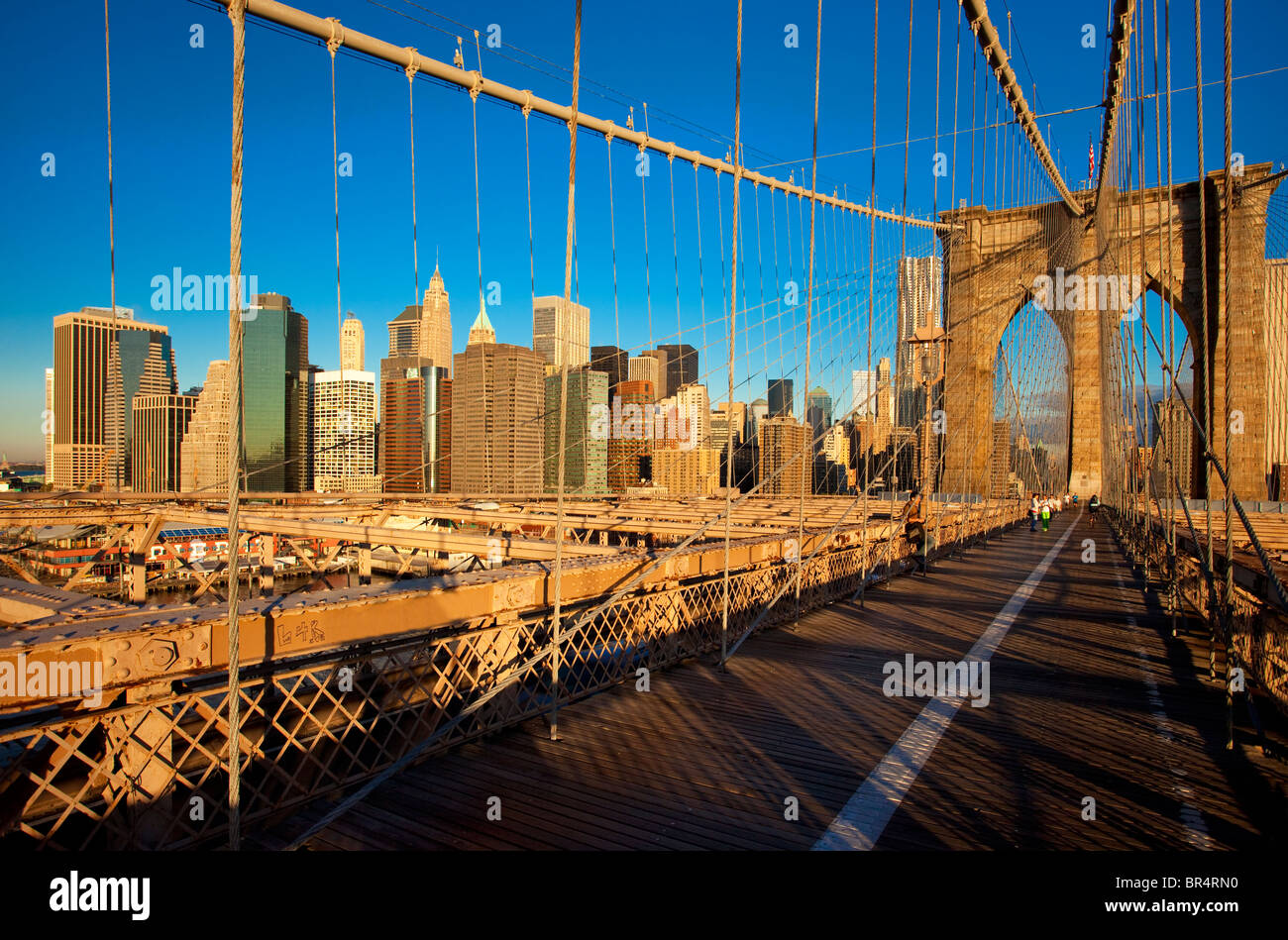 Am frühen Morgen auf der Brooklyn Bridge mit den Gebäuden des Lower Manhattan über New York City, USA Stockfoto