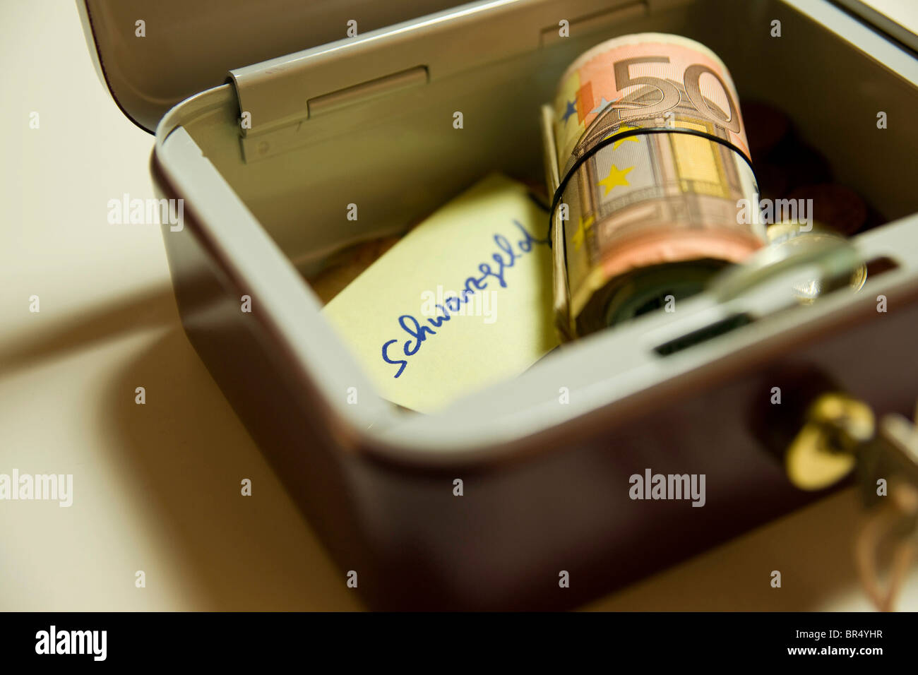 Geld in eine Box, "Schwarzgeld", schwarz Bargeld auf ein Stück Papier geschrieben Stockfoto
