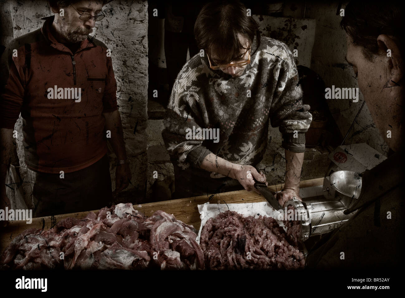 Drei Personen Schleifen das Fleisch vom Schwein bei der traditionellen Schlachtung des Schweins. Stockfoto