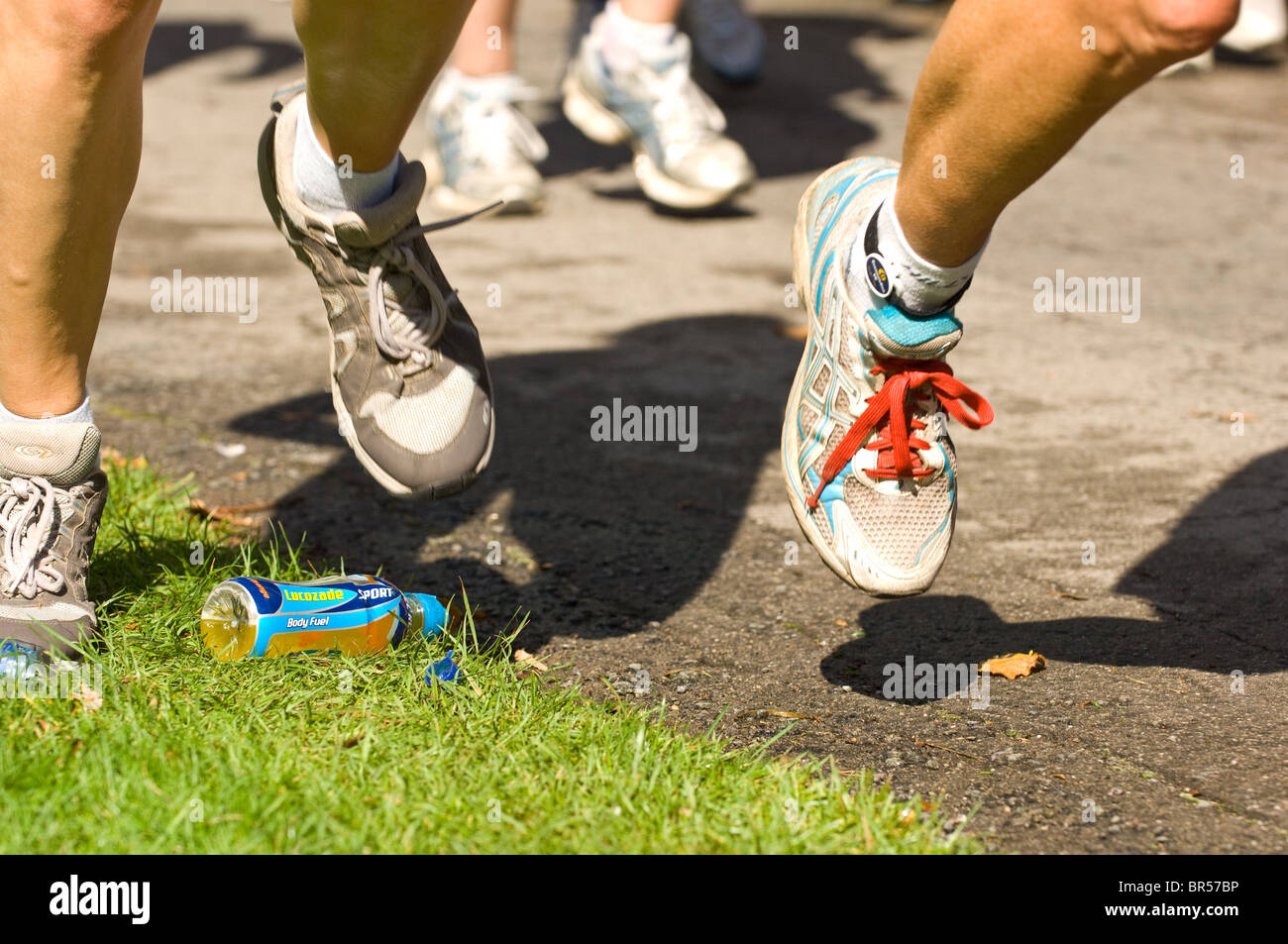 Konkurrenten in der Nottingham-Marathon verstärkt über eine weggeworfene Trinkflasche. Stockfoto