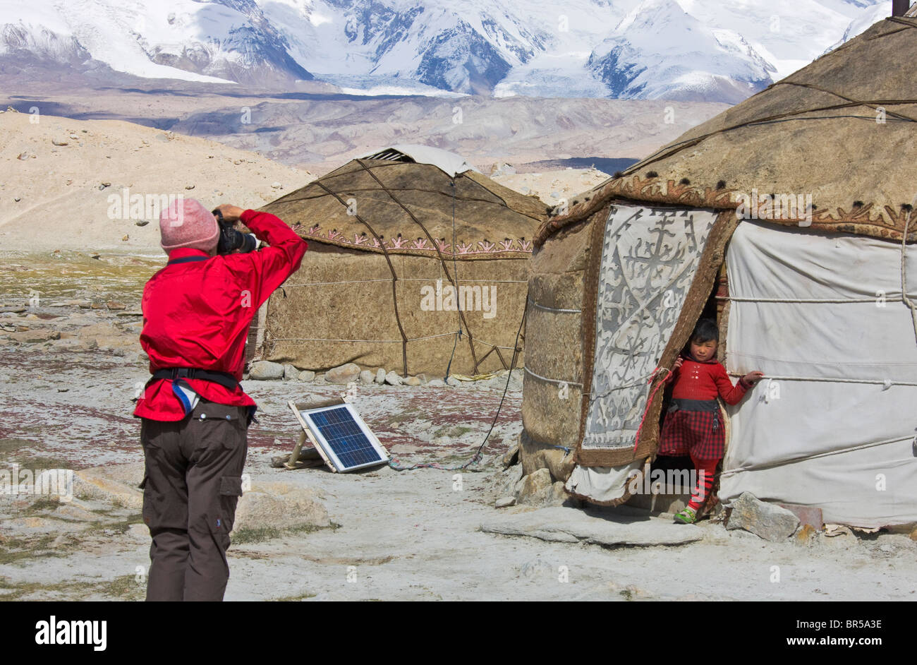 Westliche Touristen fotografieren kirgisischen Menschen Jurten Karakuli See, Mt. Kunlun in der Ferne, Pamir Plateau, Xinjiang, Kinn Stockfoto