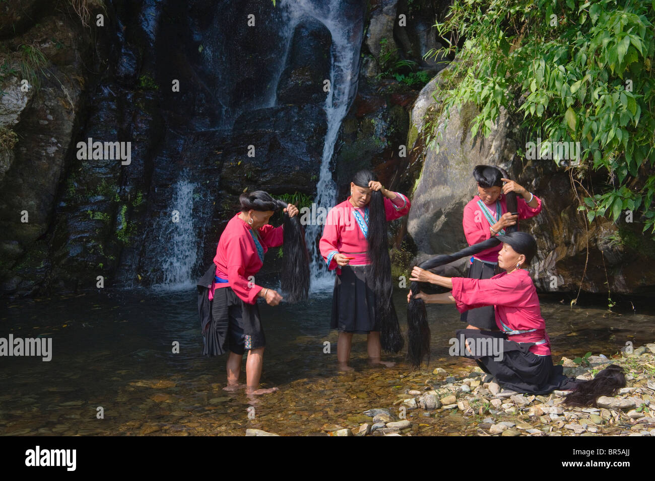 Red Yao Mädchen Bürsten lange Haare am Wasserfall, Longsheng, Guangxi, China Stockfoto
