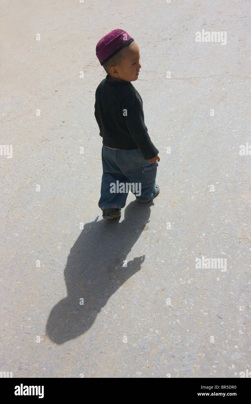 Uigurische junge Gießen Schatten auf der Straße, Hotan, Xinjiang, China Stockfoto