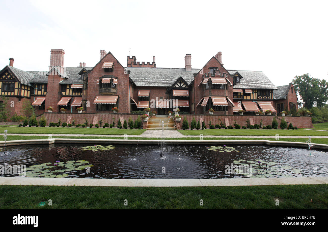 Das historische Stan Hywet Hall & Gardens in Akron, Ohio, ehemaliges Anwesen des Gründers von Goodyear Tire, das die Architektur des Tudor-Revivals und den reflektierenden Pool zeigt. Stockfoto