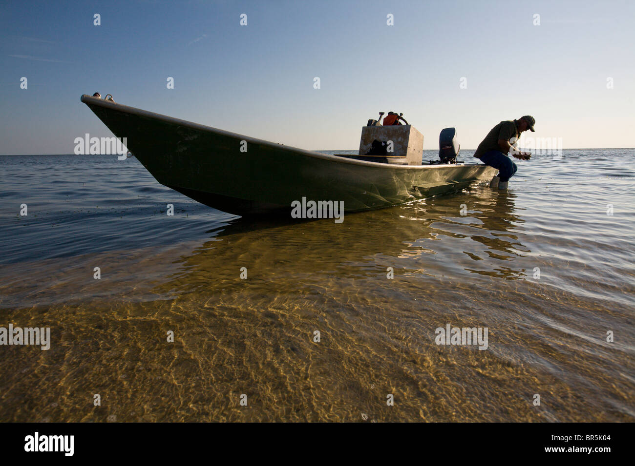Fischer sitzt auf dem Rand von seinem kleinen Boot entlang der Küste des Golfs von Mexiko in Florida Stockfoto
