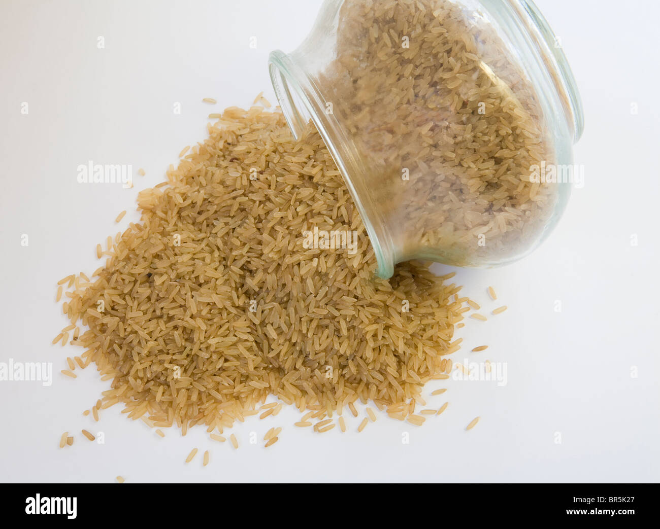 Nahaufnahme von braunem Reiskörner aus einem Glas gekippt Stockfoto