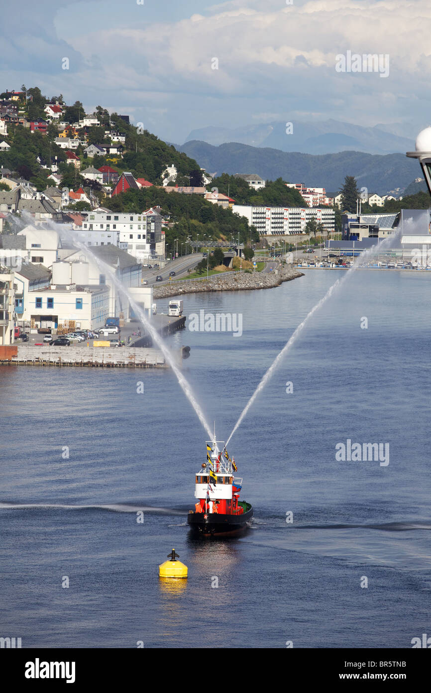 Feuer-Schlepper Besprühen mit Wasser als ein Abschied für Kreuzfahrtschiff Stockfoto