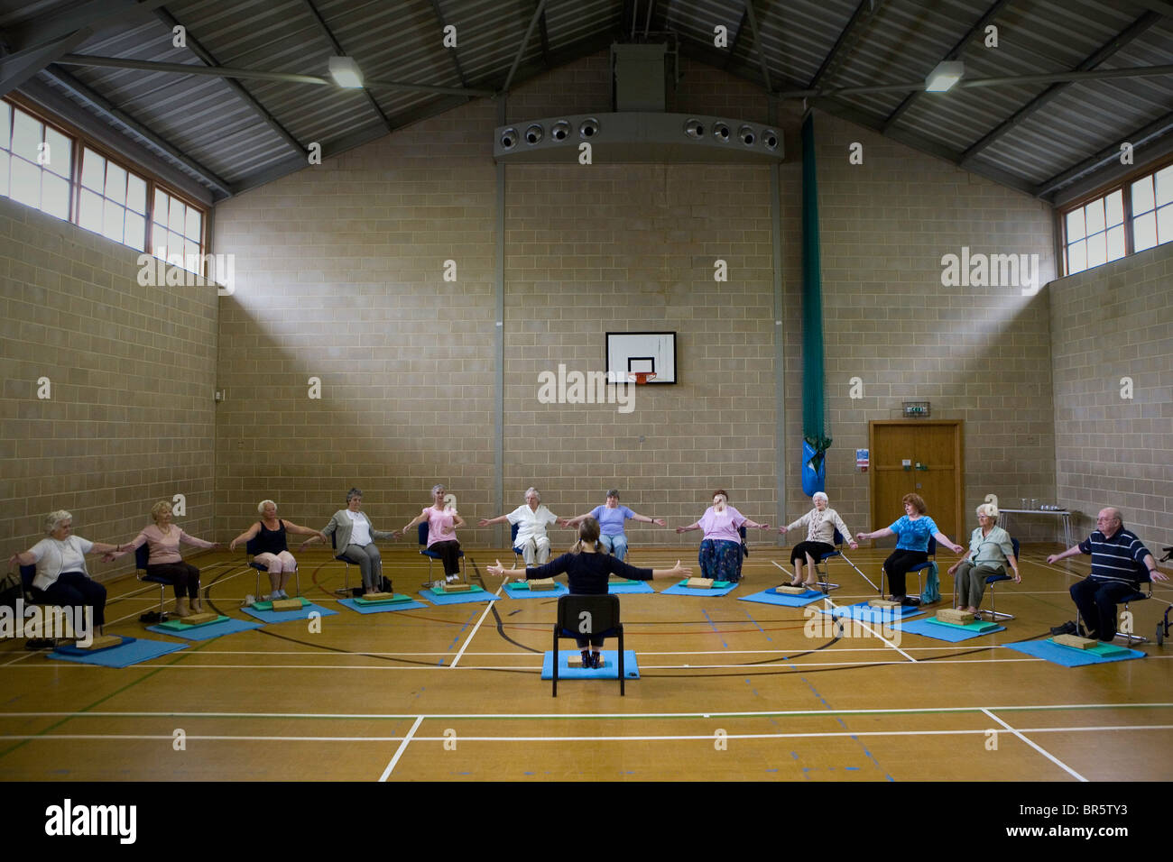 Eine Gruppe von Senioren lernen Yoga ein Tageszentrum für Nord-London. Stockfoto