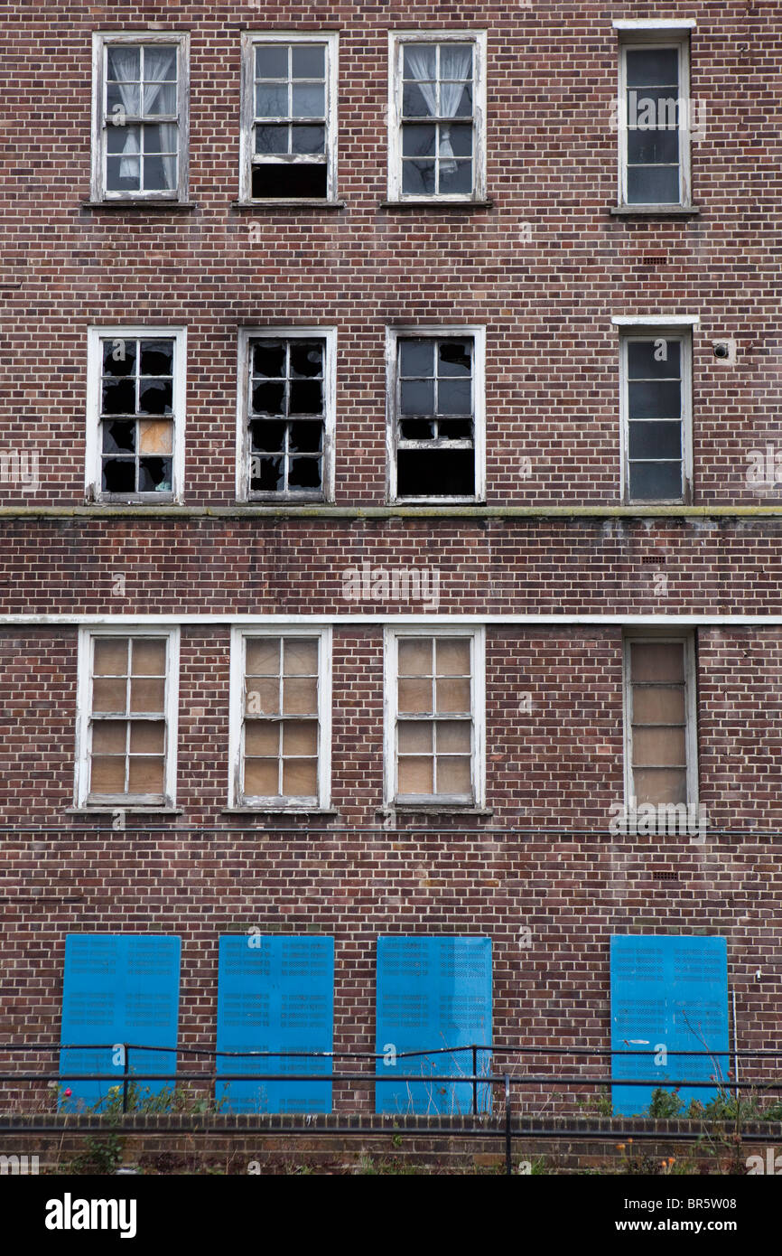 An Bord von Windows aus einem Block von leeren und Feuer beschädigte Gemeindewohnungen in Hackney, London, Vereinigtes Königreich. Stockfoto