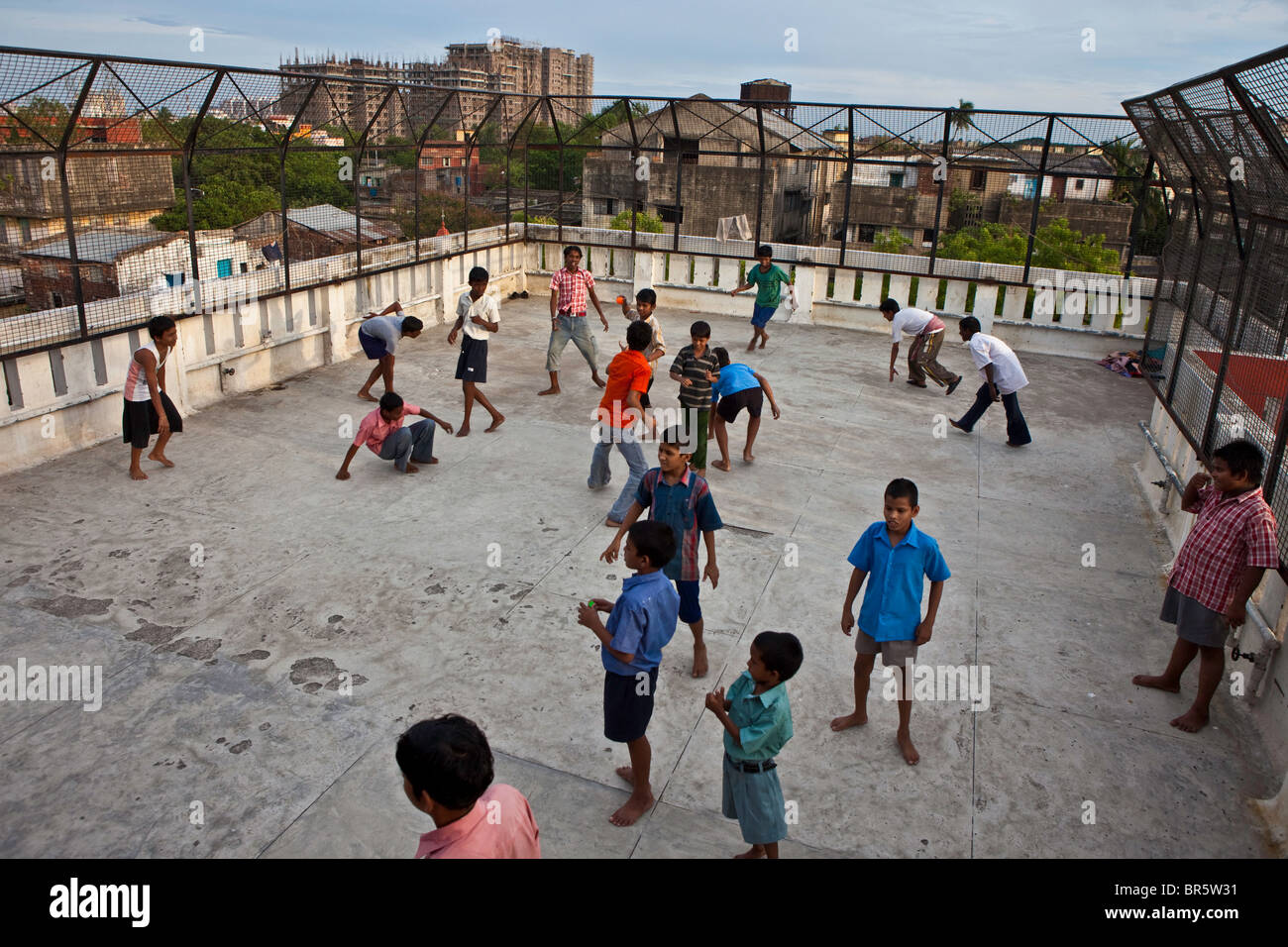 Kinder spielen Fußball auf dem Dach des CINI Halfway House für schutzbedürftige Straßenkinder in Kalkutta, Indien. Stockfoto