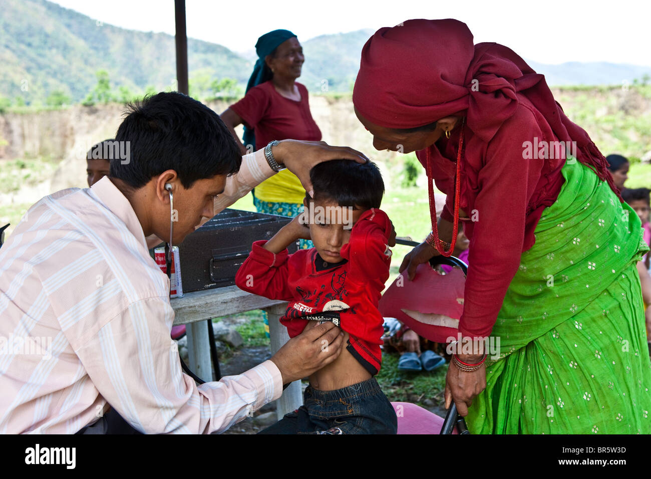 Arzt überprüft ein Kind bei Kind-Wohlfahrt Scheme Nepal (CWSN) mobile Health Clinic in Nepal. Stockfoto