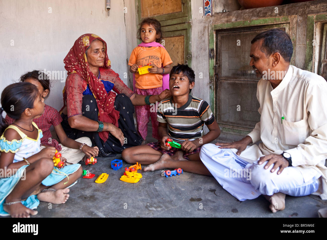 10-j hrige Meena, die taub und blind ist erforscht den Tastsinn mit ihrer Bausteine mit Hilfe ihrer Familie. Indien. Stockfoto