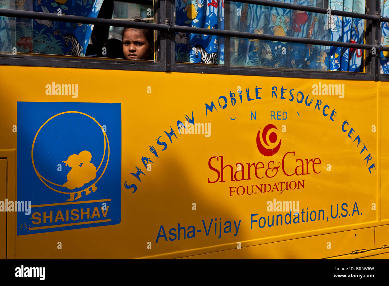 Ein Kind sieht aus dem Fenster eines der Mobile Resource Centre wird von der Shaishav Vertrauen. Bhavnagara, Indien. Stockfoto