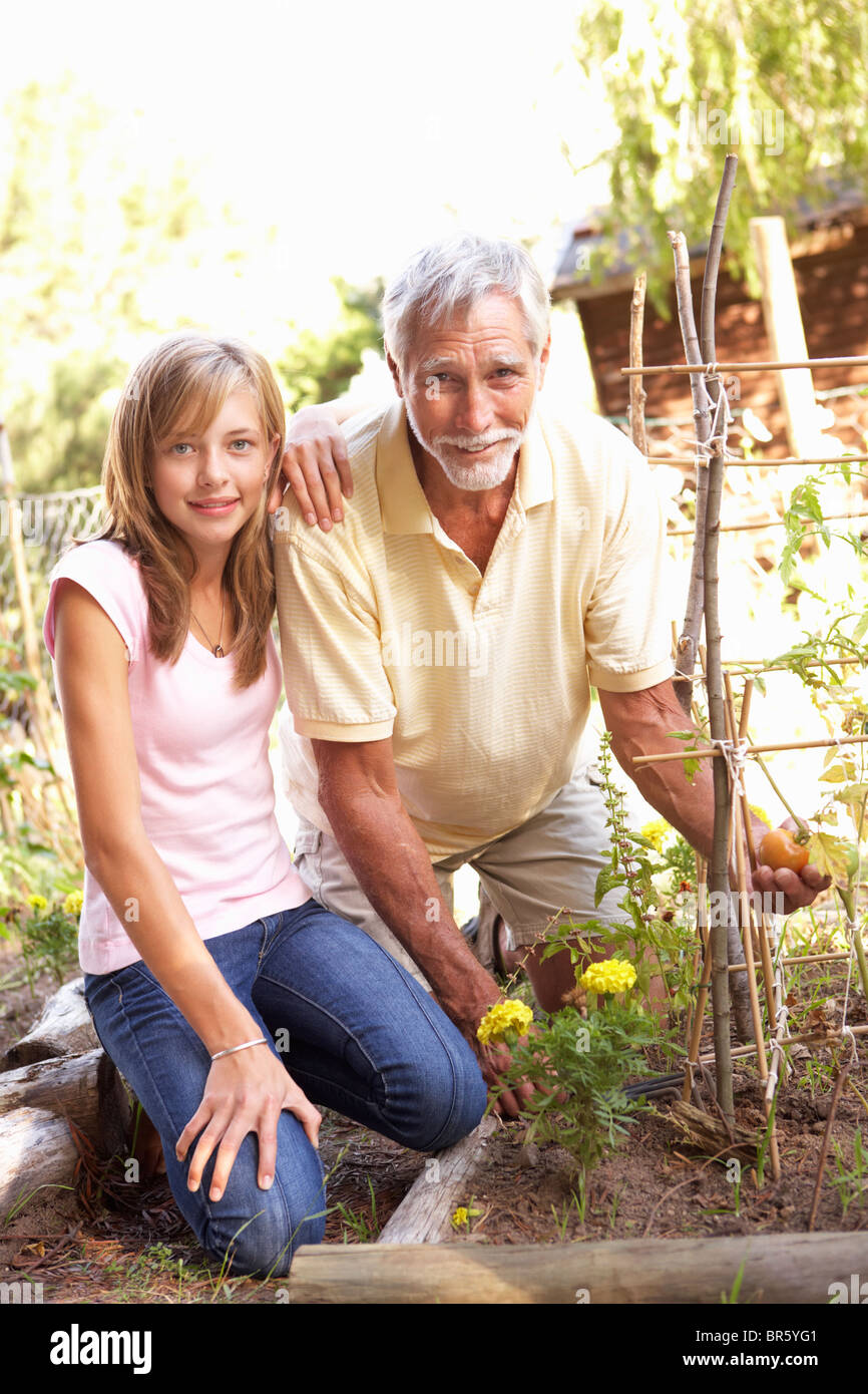 Teenager Enkelin und Großvater entspannend im Garten Stockfoto
