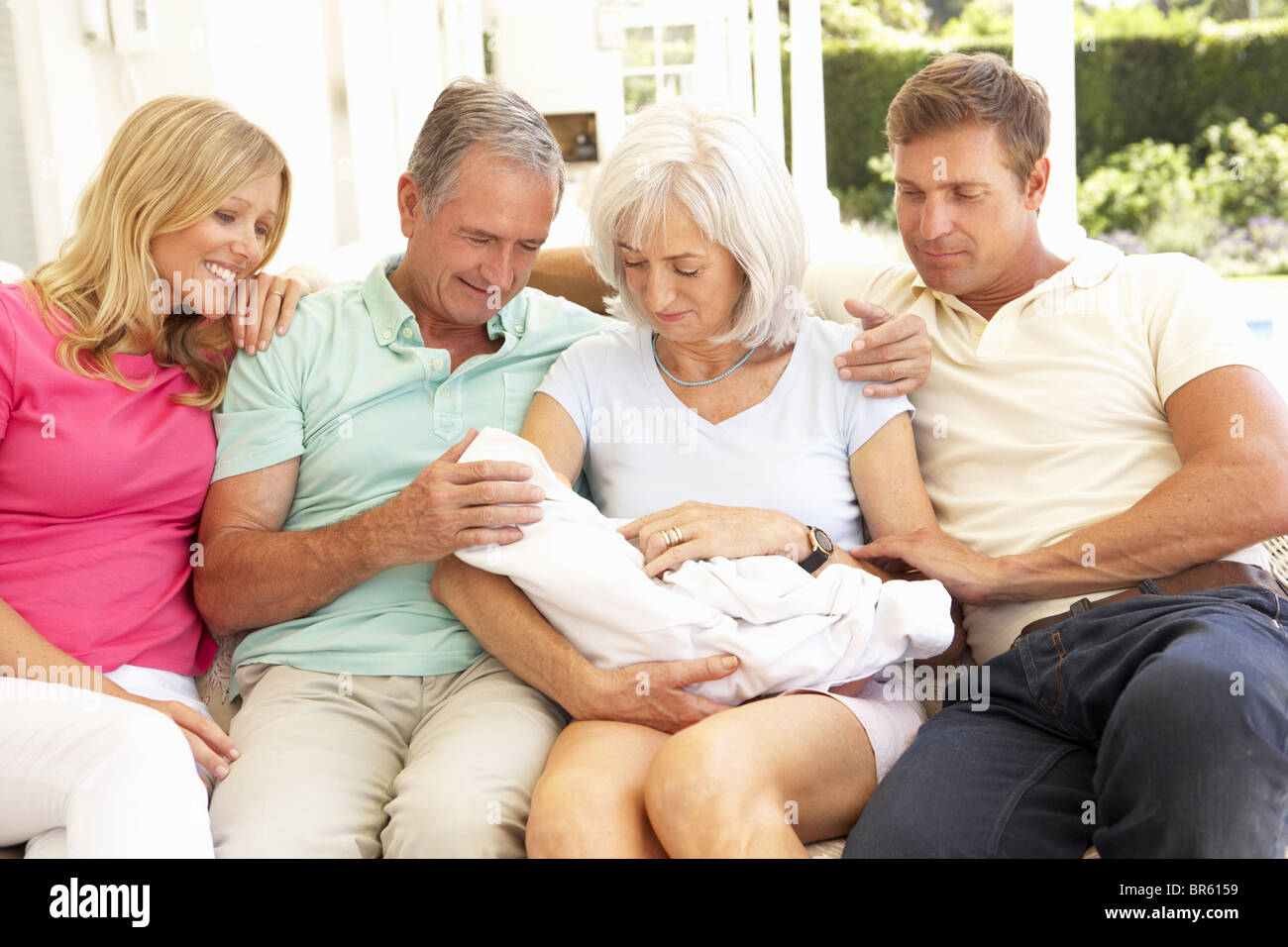 Erweiterte Familie gemütlich zusammen auf Sofa mit Neugeborenen Stockfoto