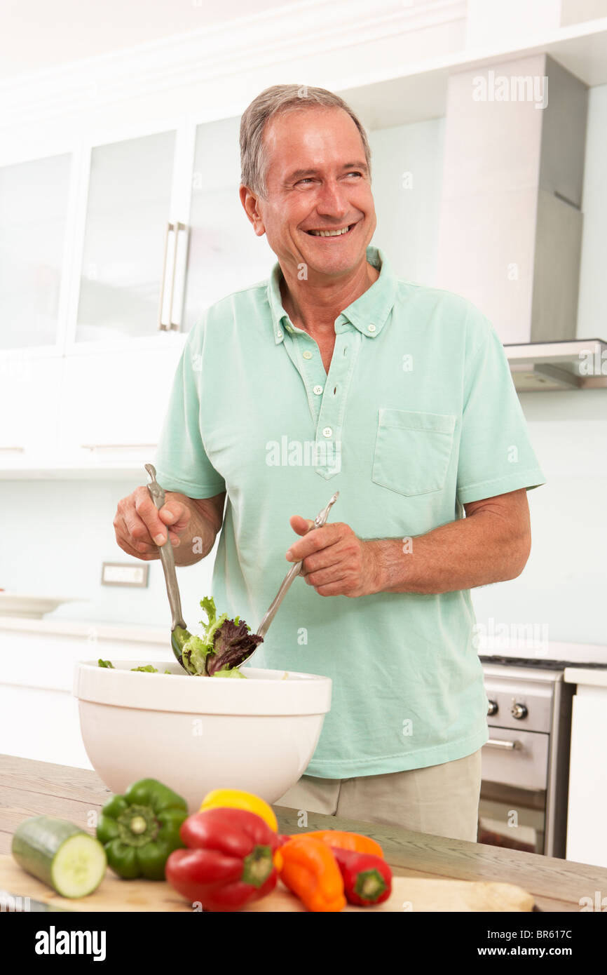 Ältere Mann bereitet Salat In modernen Küche Stockfoto