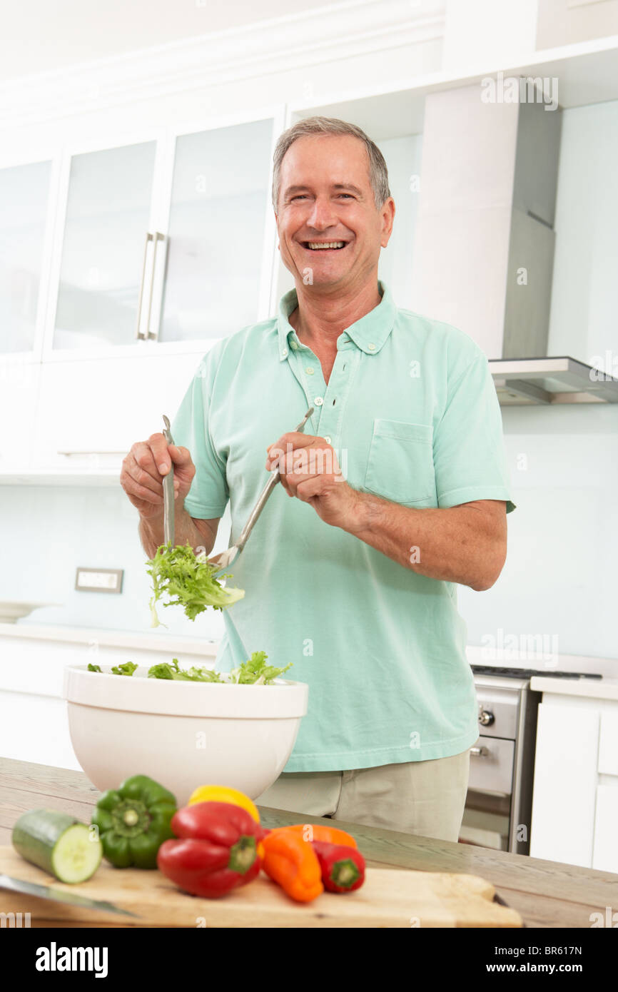 Ältere Mann bereitet Salat In modernen Küche Stockfoto